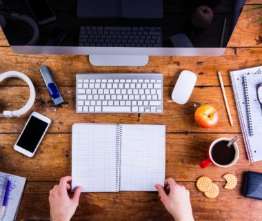 Business person working at office desk holding a notebook