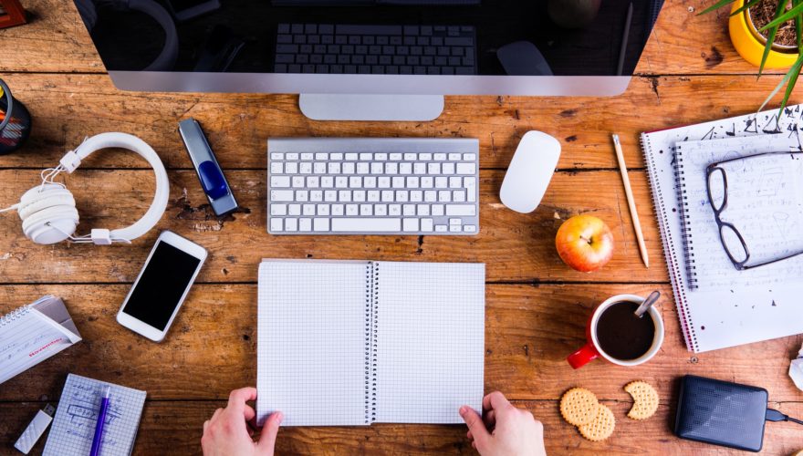 Business person working at office desk holding a notebook